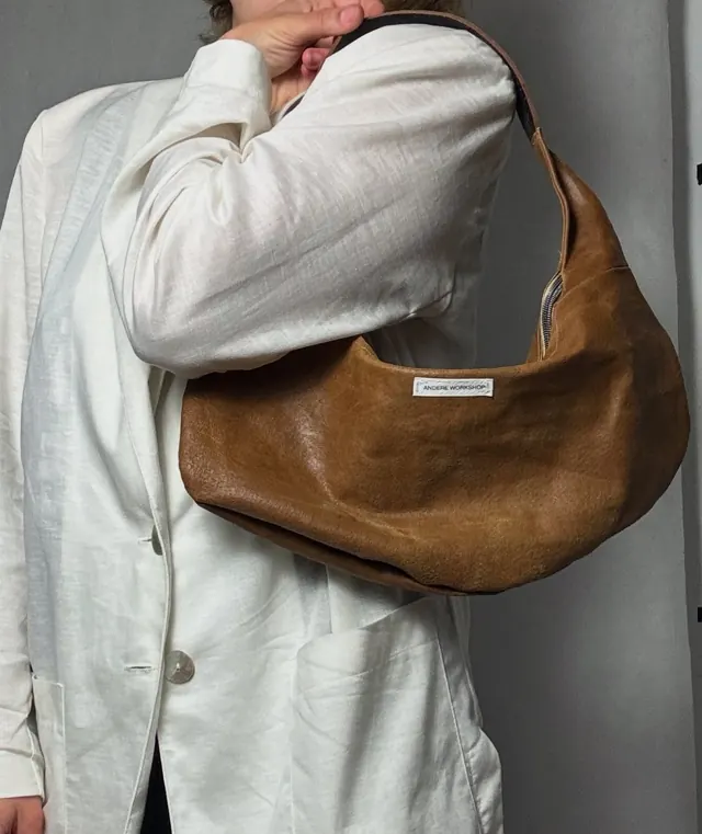 Brown leather bag with belt worn on the shoulder